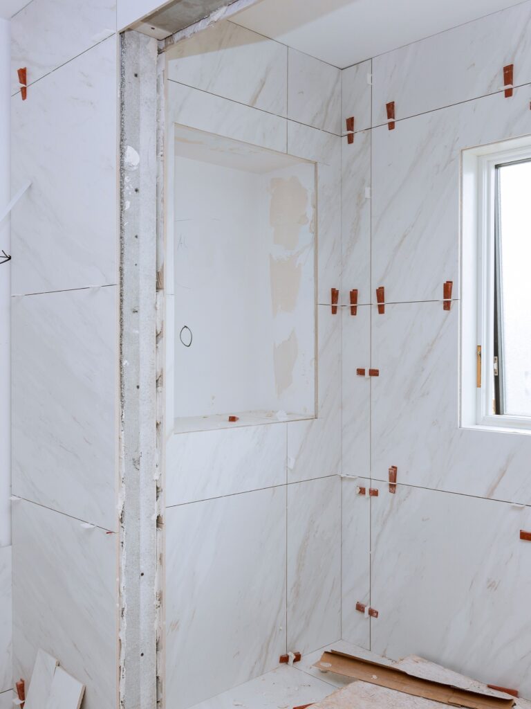 Work laying tile before applying tiles on bathroom tile.